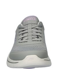 Grijze Skechers Go Walk-schoenen met een bovenwerk van gaas, vetersluiting, gevoerde zool en paarse accent op de kraag. Gladde textuur en ronde vorm.