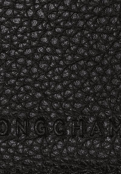 Black textured leather featuring a pebbled pattern, with embossed branding visible, creating a distinct surface detail.