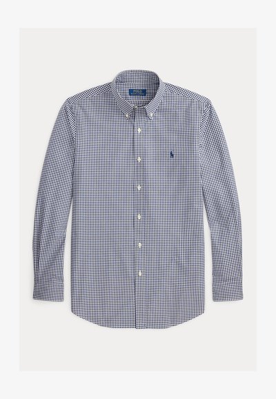 Chemise à manches longues boutonnée avec un petit motif à carreaux bleu marine et blanc et un logo bleu marine brodé sur la poitrine gauche.