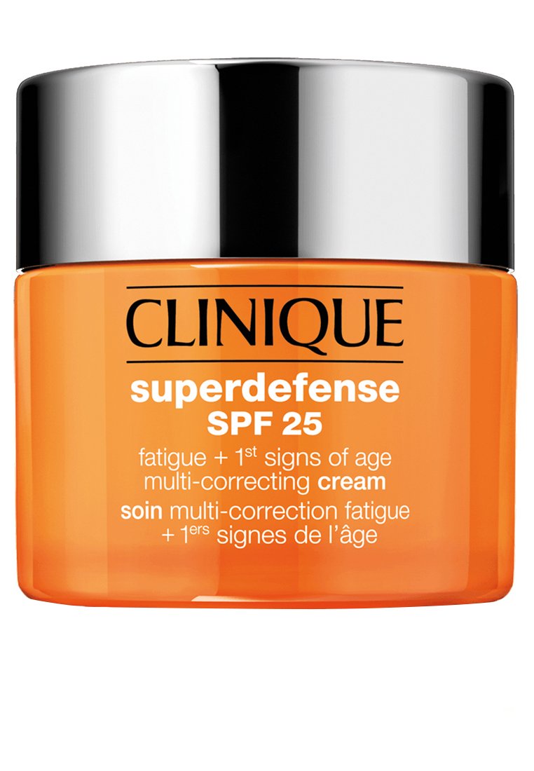 Clinique Superdefense SPF 25 kräm i en genomskinlig orange burk med ett silverlock. Texten på etiketten framhäver fördelarna mot trötthet och åldrande.