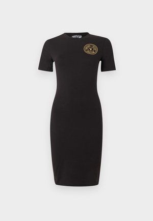 Zwarte nauwsluitende jurk tot op de knie met korte mouwen en een gouden, ronde Versace Jeans Couture-logo op de linkerborst.