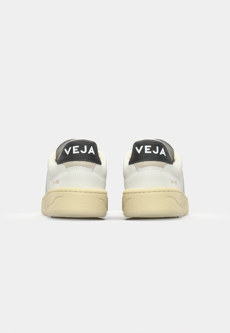 Baskets en cuir blanc avec une semelle en caoutchouc crème. Dotées d'une languette noire au talon avec le logo "VEJA" et d'accents gris. Design minimaliste.