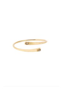 Złota bransoletka mankietowa o młotkowanej powierzchni, z dwoma smukłymi końcami, z których każdy ma mały, okrągły kamień. Prosty, otwarty design.