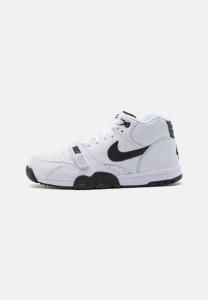 Biało-czarny, wysokogatunkowy sneaker Nike z sznurowadłami, paskiem z przodu i logo Nike swoosh po boku i przy pięcie.