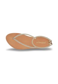 Sandalo piatto con una soletta in pelle nude e sottili strap sparkling argento. Presenta una punta rotonda e una semplice cucitura lungo i bordi.