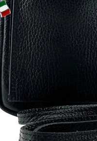 Zwarte, gestructureerde leren portemonnee die gedeeltelijk open staat met een kleine metalen speld van de Italiaanse vlag bevestigd aan de bovenlinkerhoek.