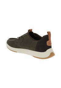 Scarpa sportiva verde e nera con suola bianca, dettagli in pelle, chiusura con lacci e design curvo. Presenta un logo sul tallone.