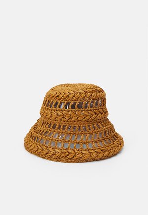 Sombrero de cubo de paja tejido en un color marrón claro, con un diseño de tejido abierto, una corona redonda y un ala ancha y flexible.