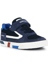 Zapatillas deportivas en color marino, fabricadas en ante y malla, con una correa de velcro, acentos en blanco y una suela multicolor con detalles en rojo y azul.