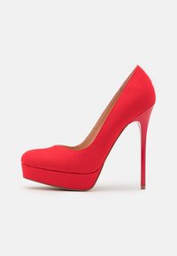 Chaussure à plateforme rouge à talons hauts en tissu doux, dotée d'un bout arrondi, d'un design épuré et d'un talon aiguille brillant.