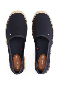 Espadrilles en toile bleu marine à enfiler avec des semelles en jute naturel, présentant une semelle intérieure avec logo marron et de petits accents rouge, blanc et bleu.