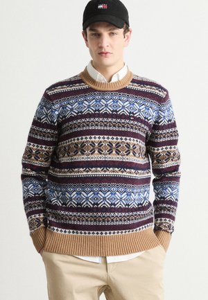 Pull en tricot avec un motif Fair Isle multicolore dans des tons de marine, beige et bordeaux. Poignets et ourlet côtelés, encolure ronde.