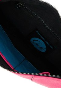 Sacchetto in pelle rosa con rivestimento nero, presenta un interno blu e una chiusura con zip; include un'etichetta con informazioni sul marchio.