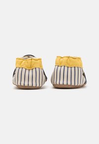 Chaussures en cuir pour tout-petits avec un talon festonné jaune, un motif rayé blanc et marine, une texture douce et des semelles en caoutchouc beige.