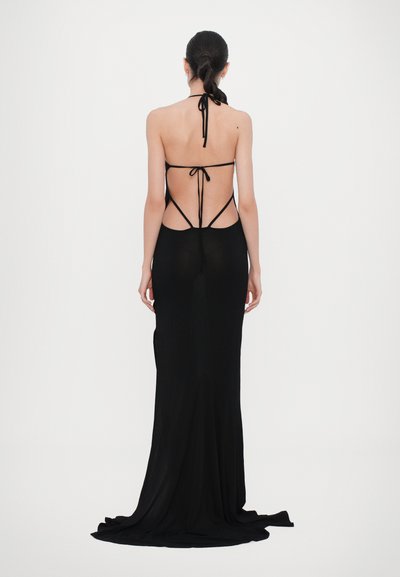 Black maxi dress with a halter neck, open back design, and thin straps. Features a sleek silhouette and smooth, flowing fabric.