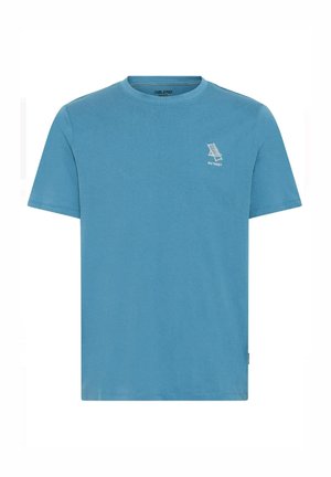 Camiseta de algodón azul claro con cuello redondo, mangas cortas y un pequeño gráfico blanco en el lado izquierdo del pecho que presenta la palabra "RETREAT".