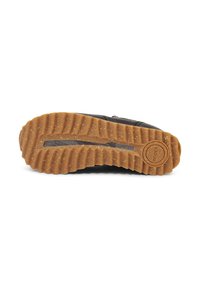 Suela de zapato con un patrón de textura de goma, que presenta una capa superior marrón y una inferior negra, etiquetada con la palabra "WODEN."