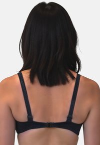 Reggiseno nero in tessuto testurizzato, con bretelle regolabili e chiusura a gancio sul retro. Presenta cuciture decorative lungo i bordi.