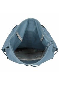 Světle modrá látková taška s velkým, otevřeným interiérem, se šedou podšívkou a menší kapsou na zip. Hladký povrch a odolný design.