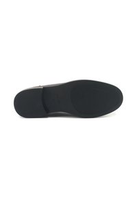Suela de zapato de goma negra con un patrón de agarre texturizado. Presenta un borde liso y una marca grabada. Diseño plano para estabilidad.
