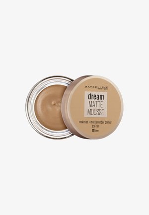 Primera Maybelline Dream Matte Mousse dans un pot métallique. Crème brun clair avec une texture lisse. L'étiquette affiche le nom du produit et la teinte.