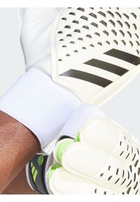 Guanti da portiere bianchi con accenti neri, grip testurizzato sui palmi e una sicura fascia bianca al polso. Dettagli di design ad alte prestazioni visibili.