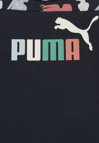 T-shirt in cotone blu navy con logo PUMA multicolore. Il logo presenta testo verde, rosso, bianco e azzurro chiaro con un'immagine di un puma che salta.