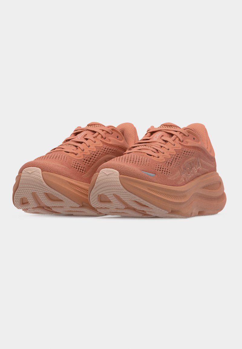 Paire de chaussures de course athlétiques couleur corail avec semelles épaisses, dessus en mesh et design à lacets, vue avant en angle sur fond blanc.