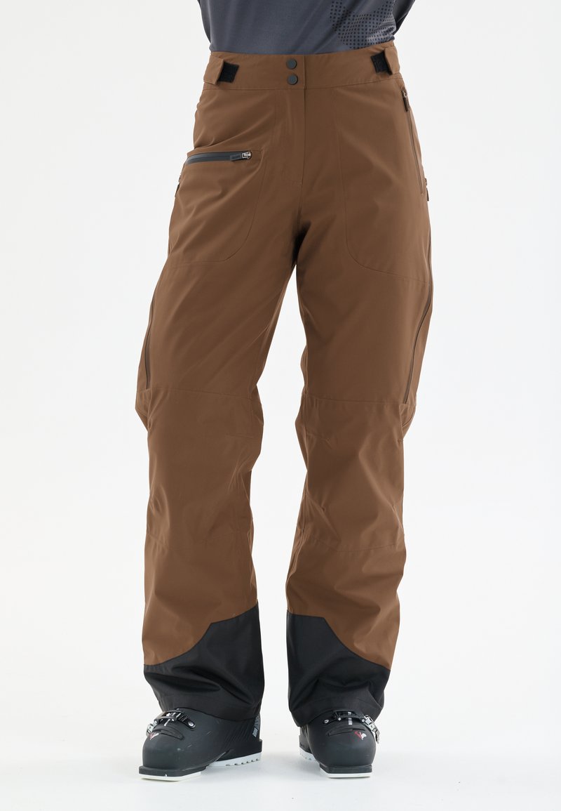 Braune Outdoor-Hosen mit glatter Oberfläche, ausgestattet mit zwei Reißverschlusstaschen, einem hohen Bund mit Knöpfen und schwarzen Akzenten an den Saumabschlüssen.