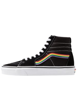 Zwarte hoge sneaker met witte veters en zool, voorzien van een golfdetail met regenboogstrepen aan de zijkant.