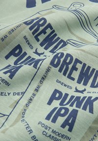 Cotton fabric featuring a light green background with bold navy blue text. Text includes "BREWED PUNK IPA" and graphics of beer cans.
