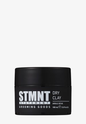 Schwarzer runder Behälter mit der Aufschrift "STMNT DRY CLAY" in weißer Schrift. Enthält 100 ml Stylingprodukt. Glatter Deckel und matte Oberfläche.