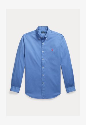 Blaues Langarmhemd mit Knopfleiste, knöpfbarem Kragen, weißen Knöpfen und kleinem roten Sticklogo auf der linken Brust.