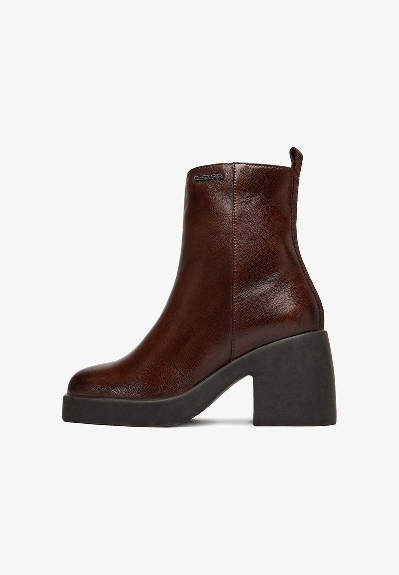 Botín de cuero marrón hasta el tobillo con tacón negro grueso, costuras laterales, lengüeta en la parte trasera y pequeño logo "G-STAR" en la parte exterior superior.