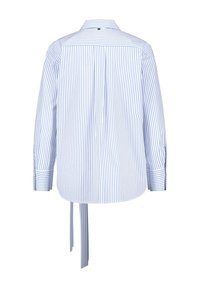 Camicia a righe in cotone blu chiaro e bianco, con maniche lunghe, dettaglio con fiocco sul retro e colletto classico. Design minimalista con chiusura a bottoni.