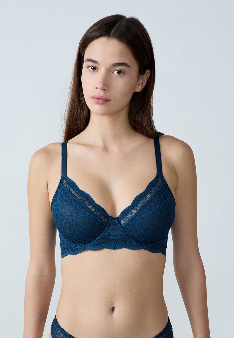 Granatowy koronkowy biustonosz braletka z falbaniastym brzegiem, trójkątnymi miseczkami, regulowanymi ramiączkami oraz geometrycznym wzorem.