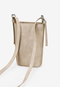 Bolso cruzado de piel beige con una correa ajustable, textura suave y un diseño minimalista. Presenta una forma rectangular y detalles en acero inoxidable.
