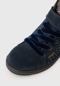 Navy suede sneaker with blue velvet laces, dotted pattern details, and a black rubber sole. Features a Gore-Tex tag on the side.