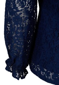 NAVYblaue Spitzenbluse mit langen, durchsichtigen Ärmeln. Mit floralen Mustern und elastischen Rüschensäumen für zusätzliche Details und Textur.