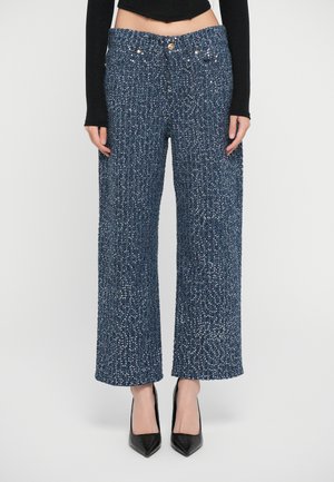 Wide-leg trousers in textured blue fabric, featuring a high waistband with gold hardware accents and a loose fit from hips to ankles.