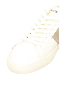 White leather sneaker with beige suede side panel, white laces, and "Scotch & Soda" branding on the tongue.