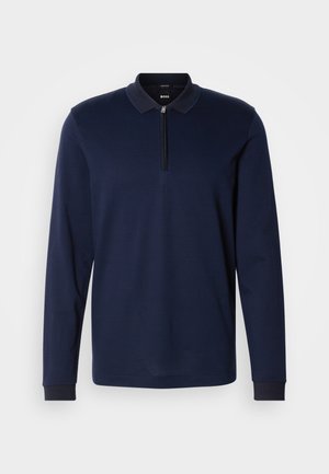 Marineblaues Langarm-Polohemd mit Reißverschlusskragen, strukturiertem Stoff und kontrastierendem dunklem Kragenbesatz. Verfügt über eng anliegende Bündchen und ein dezentes Muster.