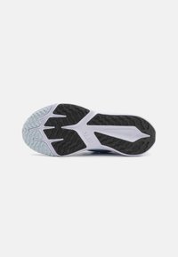 Semelle de chaussure de sport en noir et blanc avec un motif de traction en caoutchouc, des bords courbés et des accents bleu clair sur le bord extérieur.