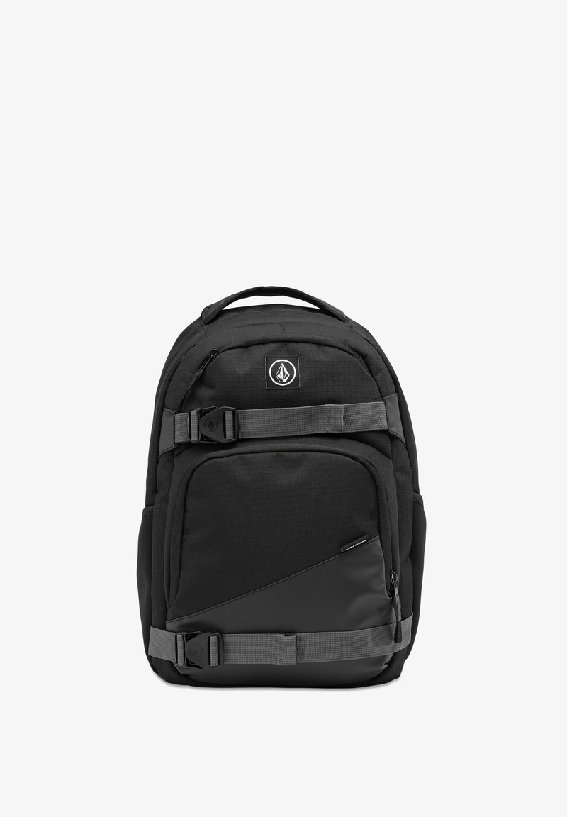 Svart ryggsekk med teksturert stoff, flere glidelåslommer, en stor hovedseksjon og justerbare stropper. Har logo og spenner.