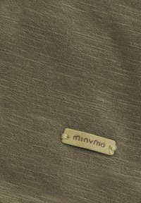 Olijfgroene stof met een gemarmerd patroon, met een beige label dat met touw is bevestigd, waarop de naam "minymo" in paarse letters is weergegeven.