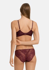 Ensemble de soutien-gorge et culotte assortis bordeaux avec des détails en dentelle, des bords sans couture et des bretelles ajustables, vu de derrière.