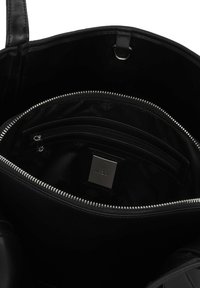 Svart läderhandväska med ett rymligt innerrum, utrustad med en dragkedjeficka och en silvrig logodetalj. Slät textur och enkel design.