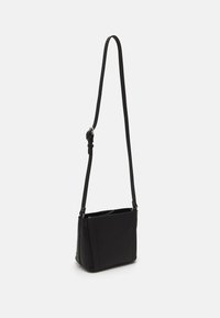 Sort skuldertaske med en glat tekstur, rektangulær form, justerbar rem og minimalistisk design. Har diskrete side sømme og hardware detaljer.