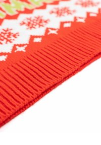 Maglione rosso in lavorazione a maglia con motivi geometrici e fiocchi di neve bianchi, con una texture a coste all'orlo.