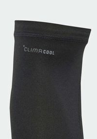 Černé sportovní legíny s hladkou, prodyšnou látkou. Na nich je šedé logo „CLIMACOOL“, zdůrazňující technologii odvádění vlhkosti.